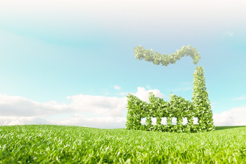 Green field with blue sky and a factory made out of leaves